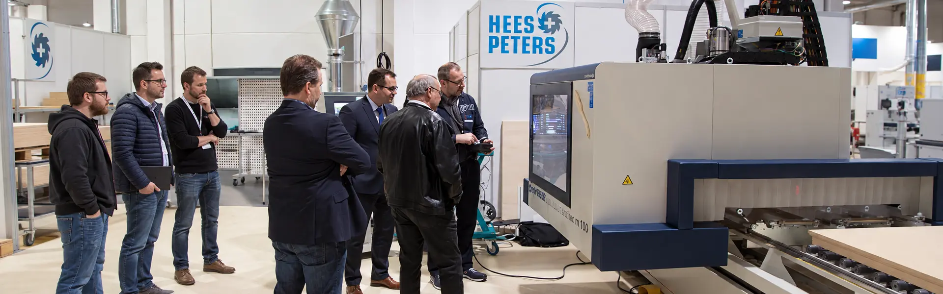 Fachbesucher verfolgen eine Maschinenvorführung am Stand von HEES+PETERS auf der HolzTek